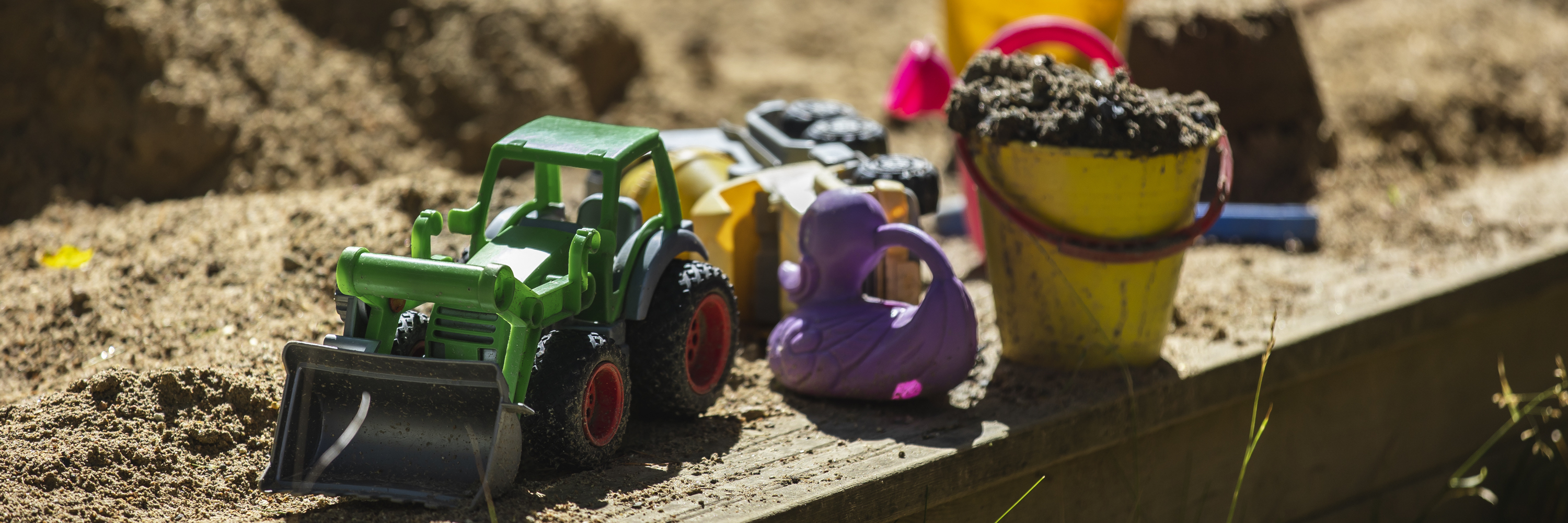 Children's sand toys on the edge of a sandpit.