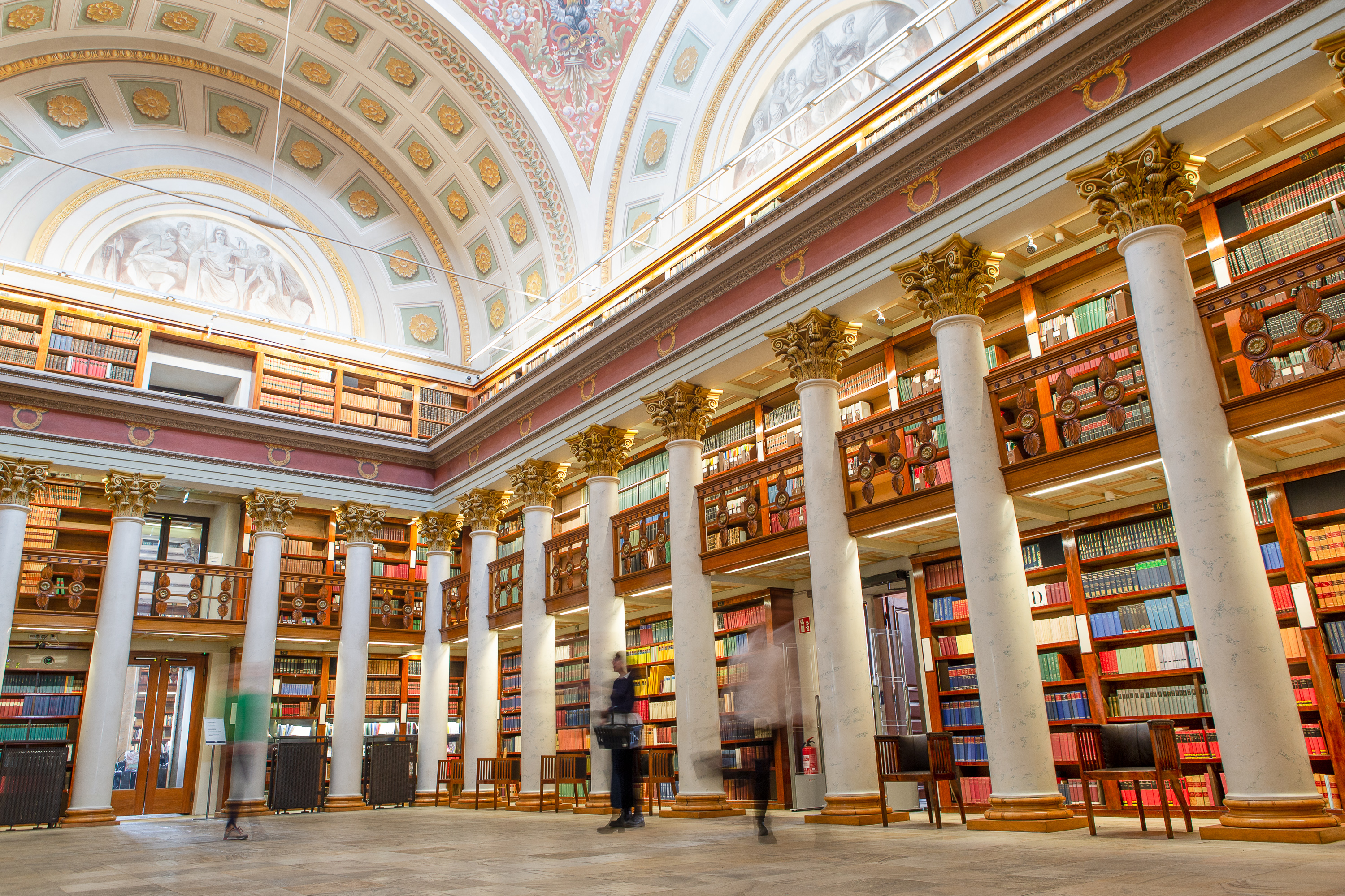 National Library of Finland, photo shows the historical main floor with white columns and high arching white ceiling.